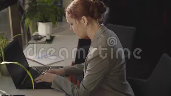 在笔记本电脑键盘上打字的白人女人的肖像坐在空地上的自信的女办公室工作人员视频的预览图