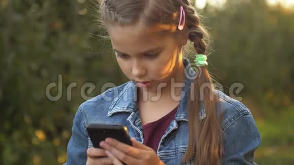 孩子正在使用手机孩子在看设备屏幕小女孩在孩子们玩数字游戏视频的预览图