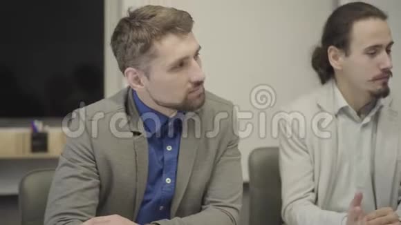 镜头从两名白人男性办公室工作人员的脸转移到中年女性首席执行官坐在桌子旁交谈视频的预览图