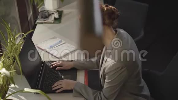 一位年轻的白人妇女坐在露天办公室里看着笔记本电脑屏幕成功商人的肖像视频的预览图