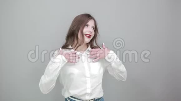 穿着白色衬衫的开朗的女人做着摇滚的手势露出肌肉微笑视频的预览图