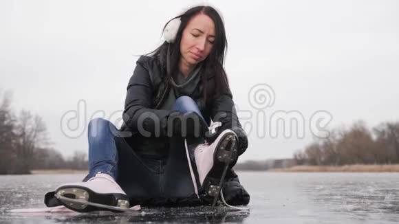 穿着手套的女孩在溜冰场系鞋带视频的预览图