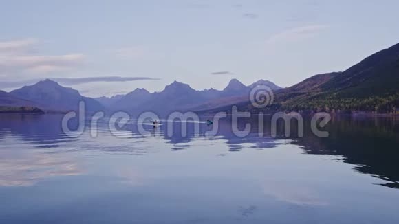 太阳下山的冰川湖上的独木舟视频的预览图