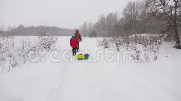 爸爸和女儿正穿过一片雪林游客在冬天徒步旅行圣诞节假期家庭旅行视频的预览图