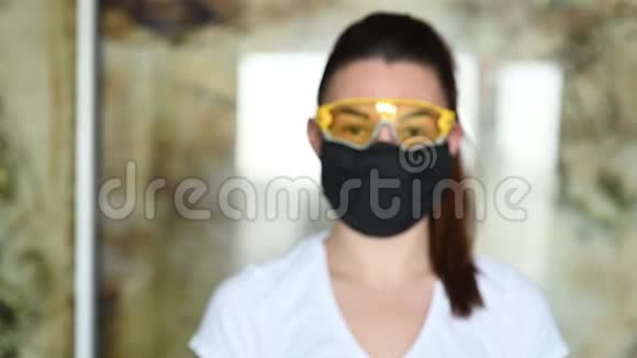 戴防护面罩眼镜和手套的女孩喷洒防腐剂以防止感染视频的预览图
