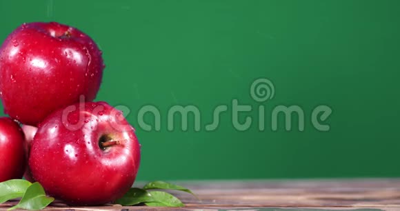 雨中的鲜红色苹果放在木桌上视频的预览图