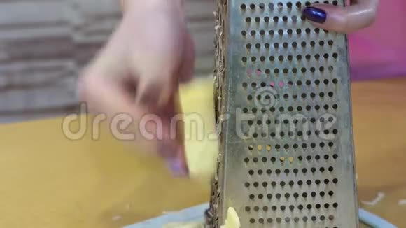 女性手与指甲擦奶酪在grater特写视频的预览图