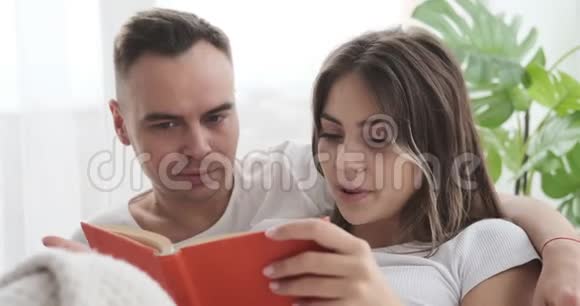 一对夫妇在床上一起看书视频的预览图
