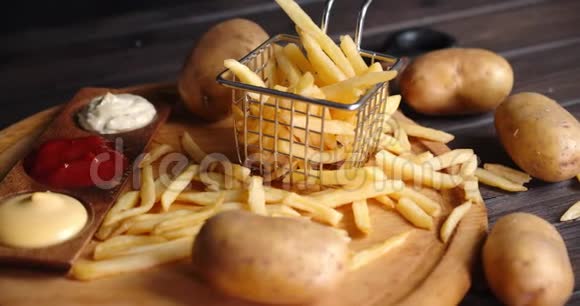 炸薯条放在切菜板上的篮子里里面有各种酱汁视频的预览图