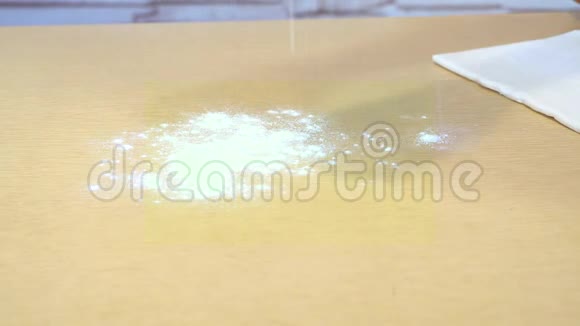 在厨房的黄桌上在可见的手的框架内白面粉溢出视频的预览图