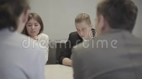 白种人年轻男女坐在商务会议上与同事讨论项目的肖像女性视频的预览图