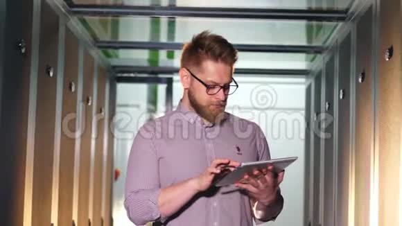 男技术员正在服务器单元中的平板电脑上工作视频的预览图