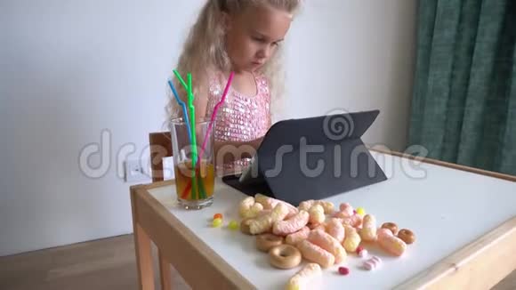 小女孩坐着玩电脑平板电脑各种糖果万向节运动视频的预览图