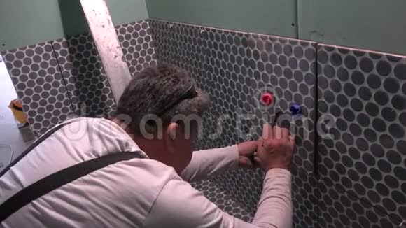 熟练工人在瓷砖上做记号在水管上打洞视频的预览图
