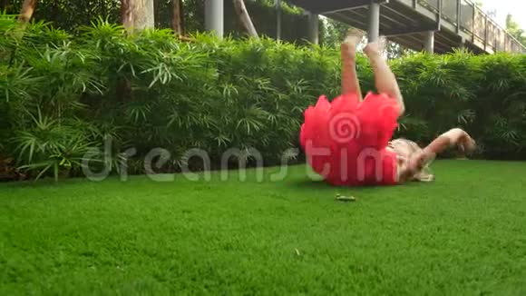 女孩子有时在绿草上跌倒儿童造成筋斗视频的预览图