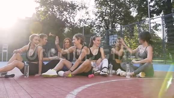 微笑快乐运动苗条的女人在健身课后休息在公园运动场上互相击掌视频的预览图