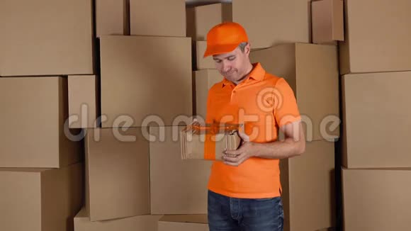 穿橙色制服的送货员把损坏的包裹寄给顾客棕色纸箱背景法律和不专业视频的预览图