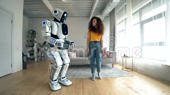 年轻的女人和机器人在欢快地跳舞机器人人形半机概念视频的预览图