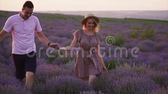 两个情人牵着手走在薰衣草的田野上慢动作视频的预览图