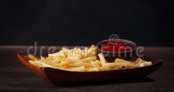 薯条放在木盘上加番茄酱慢慢旋转视频的预览图