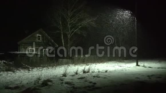 在俄罗斯的村庄里下雪冬天的夜晚有木制的旧房子视频的预览图