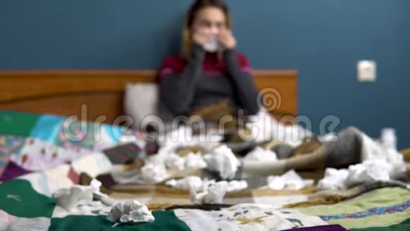 一个年轻的女人吹鼻子扔纸巾纸那个女孩躺在床上病了视频的预览图