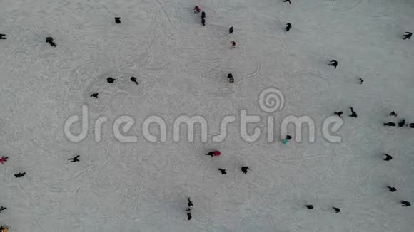 人们在白天在明亮的溜冰场上滑冰空中自上而下的视野视频的预览图