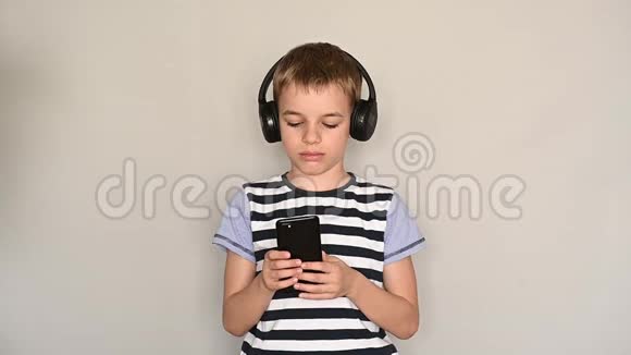 青少年使用智能手机发短信带着耳机听音乐视频的预览图