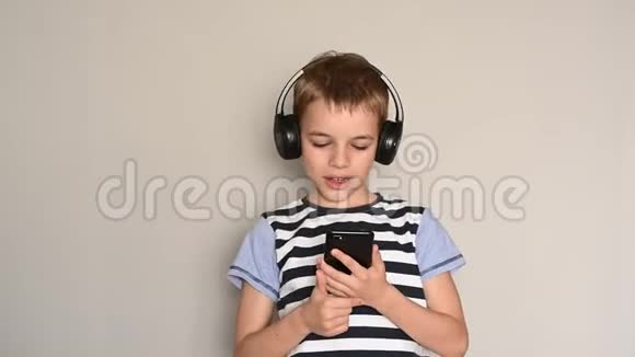 青少年使用智能手机发短信带着耳机听音乐视频的预览图