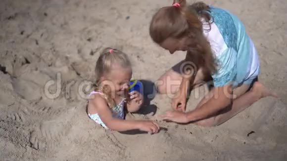 女儿被埋在沙子里妈妈在玩沙子视频的预览图