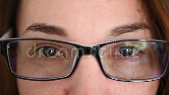 戴眼镜的女人看着相机愉快地微笑着的肖像关门视频的预览图