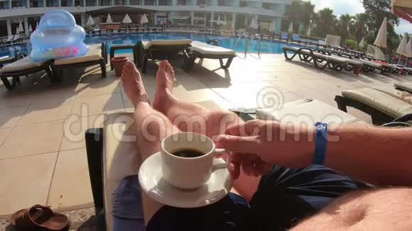 一个男人在游泳池附近喝咖啡视频的预览图