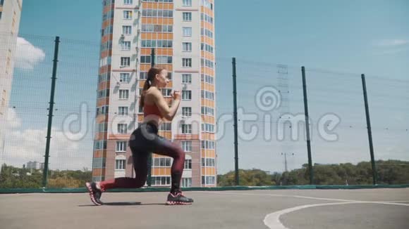 运动女运动员在高楼林立的街道上健身做运动攻击慢动作视频的预览图