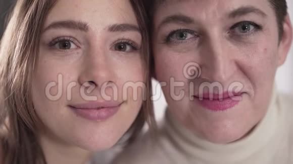 两个白人妇女极端的特写镜头看着镜头微笑着年轻的女儿和她年轻的女儿视频的预览图