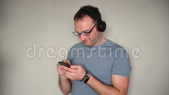 快乐男人在听耳机音乐时使用手机视频的预览图