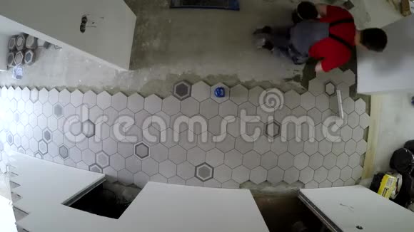 专业工人在地板上铺设六角石块砖时间推移视频的预览图