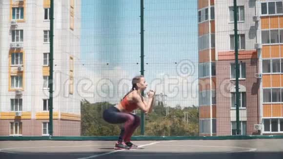 年轻的女运动员在街上从事健身活动培训用维普瑞加做运动蹲慢动作视频的预览图