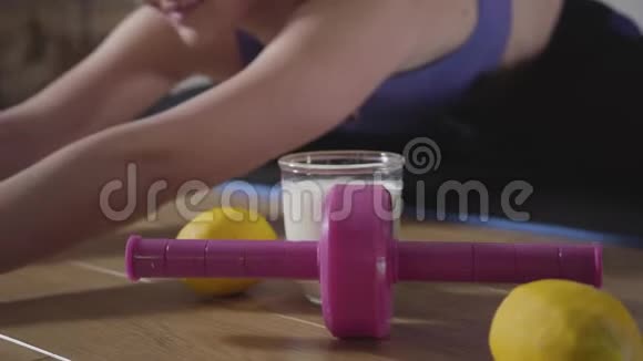 地板上的粉红色滚轮橘子和蛋白鸡尾酒的特写年轻漂亮的高加索女人视频的预览图