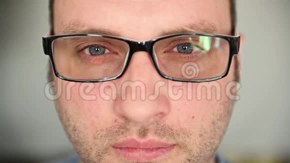 一个戴着蓝眼睛眼镜的帅哥看着相机戴眼镜揉揉眼睛视频的预览图