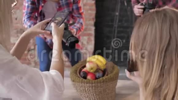 在主课期间摄影师学会用相机和手机在木桌上的篮子里拍照水果视频的预览图