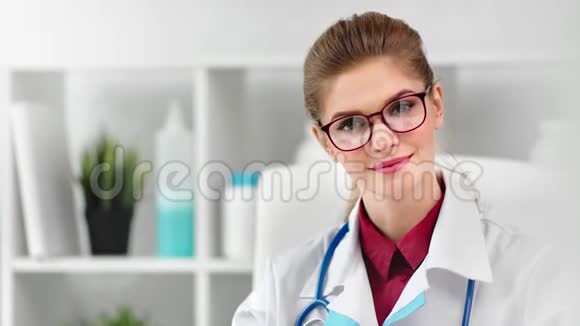 戴着眼镜摆着制服的年轻女医生看镜头特写的画像视频的预览图