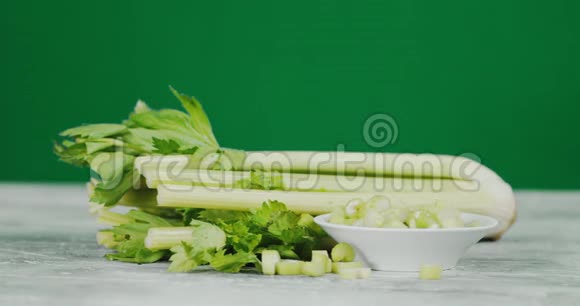 一串芹菜和切好的芹菜在盘子里慢慢旋转视频的预览图