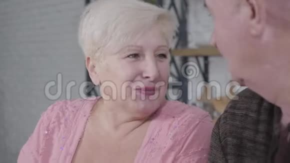 一幅美丽成熟的白种人女人的肖像棕色的眼睛与秃头丈夫有感情地交谈有吸引力的退休人员视频的预览图