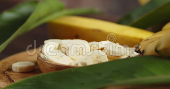 新鲜香蕉片在盘子上叶子慢慢旋转视频的预览图