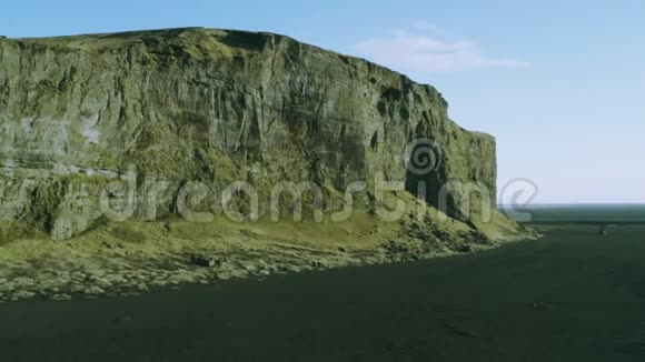 鸟瞰被黑沙包围的大岩石山在黑色沙漠荒野中带山的鸟瞰视频的预览图