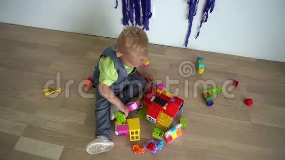 小男孩在木地板上玩装配构造器部件万向节运动视频的预览图