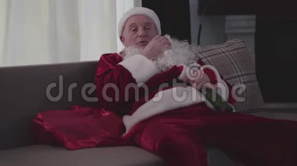 穿着圣诞老人服装的白种人的特写镜头抓着胸口睡着了孤独的成熟男人视频的预览图