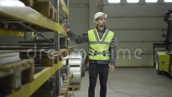 男性白种人工人在背心和头盔检查仓库因为他的同事上来握手金属植物视频的预览图