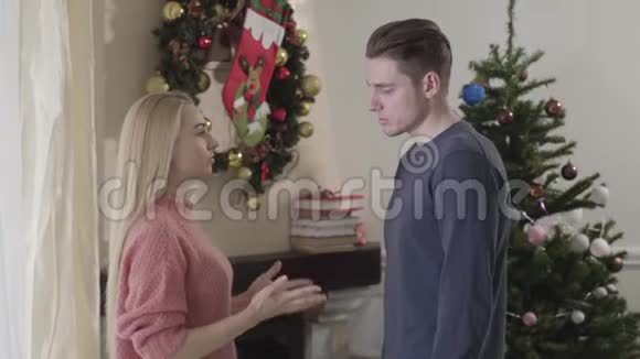 在圣诞夜争吵的白种人夫妇的侧视不快乐的男人和女人说话和打手势男人穿越视频的预览图