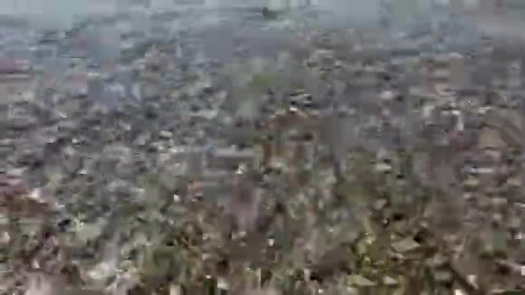 海浪在阳光明媚的天气里冲刷着卵石海岸海水中的鹅卵石在阳光下闪闪发光视频的预览图